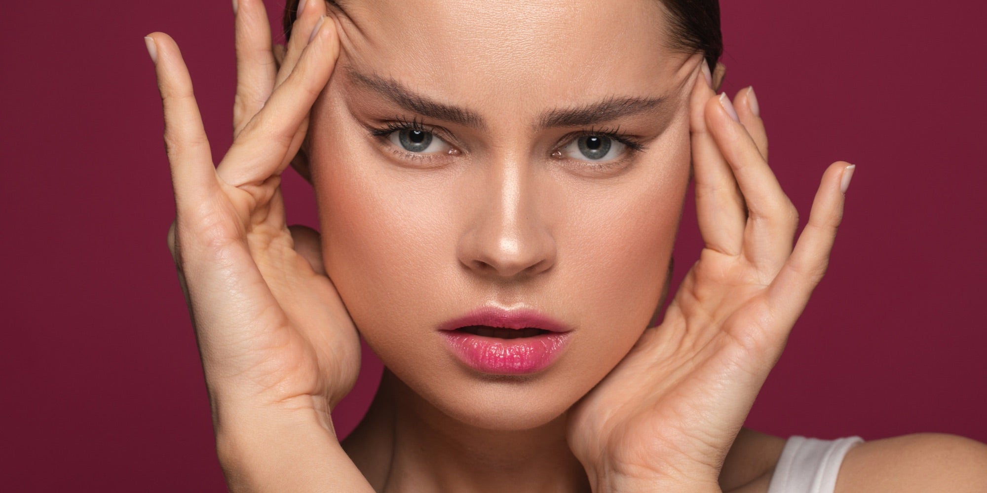 Woman touching her facial skin and looking perturbed 