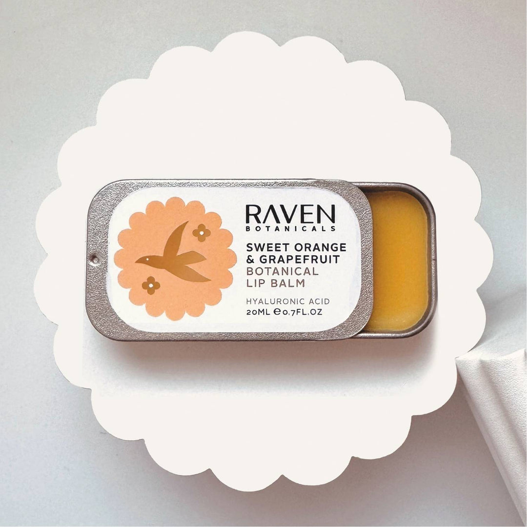 Lip balm in a tin with 'Raven Botanicals' branding on a white background