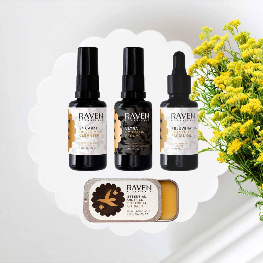 Raven skincare products including cleanser, serum, facial oil, and lip balm with yellow flowers in the background.