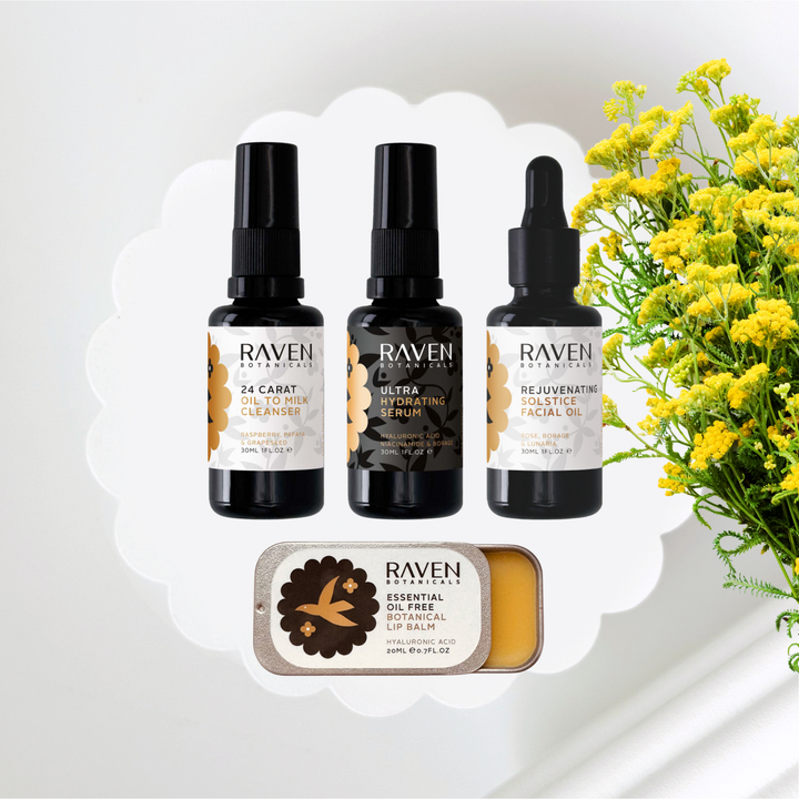 Raven skincare products including cleanser, serum, facial oil, and lip balm with yellow flowers in the background.